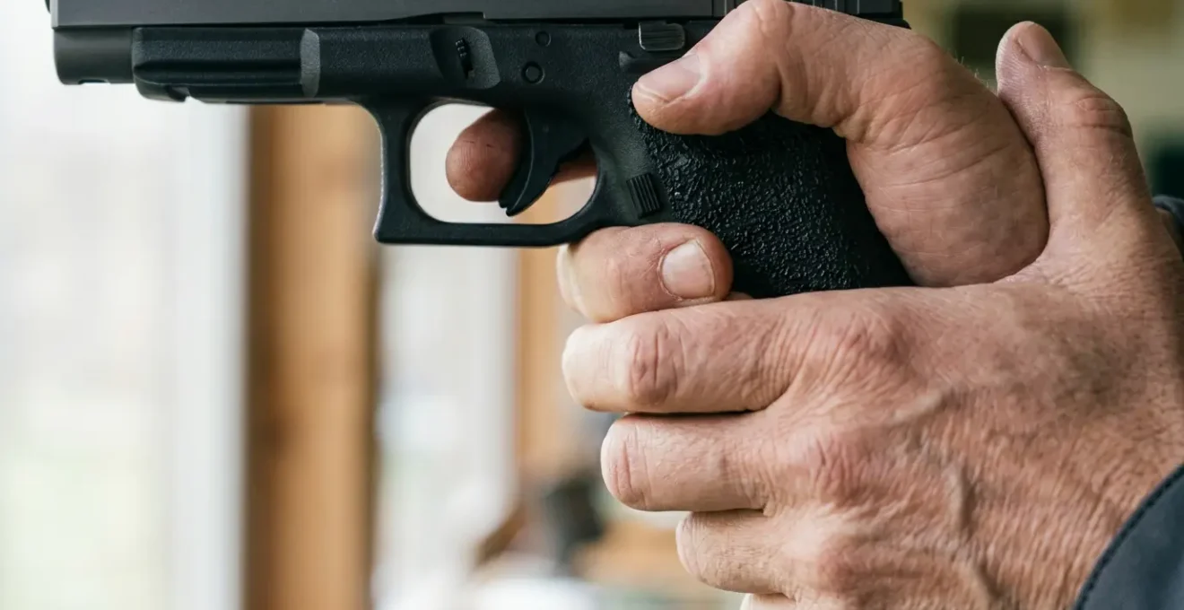 Tireur sportif ajustant sa prise en main sur la poignée d'un pistolet de compétition