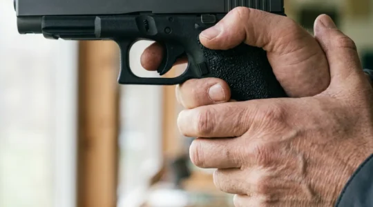 Tireur sportif ajustant sa prise en main sur la poignée d'un pistolet de compétition