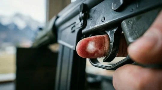 Gros plan sur la main d'un tireur sportif au moment précis du contact avec la détente d'un fusil d'assaut Fass90 suisse